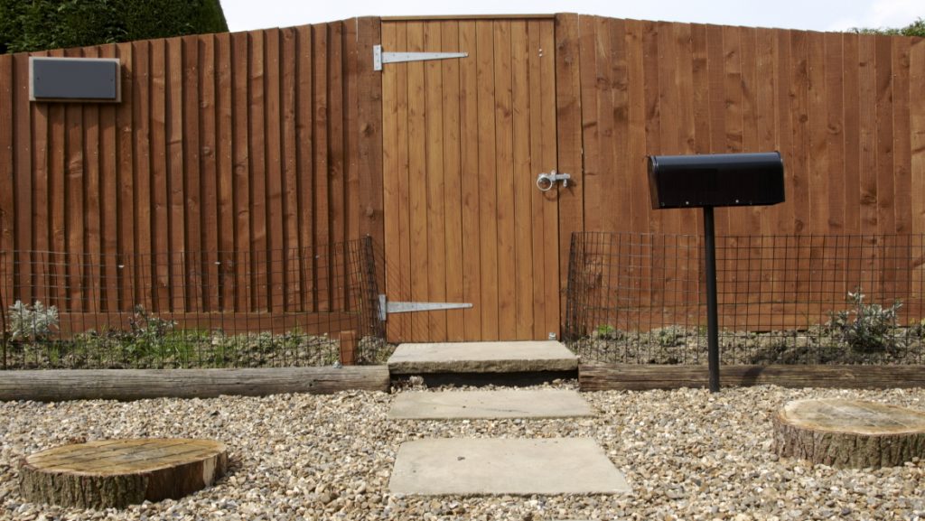 A new wooden fence with a path leading to the gate